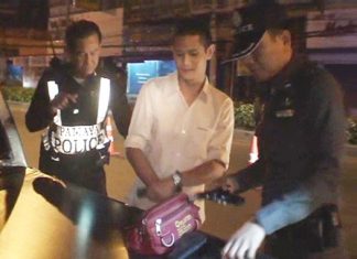Komsan Sima, center, is arrested for illegal firearm possession.